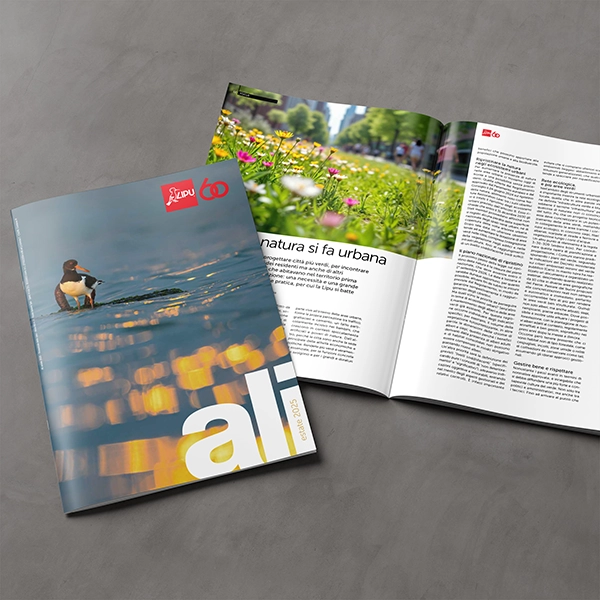 Due riviste su una superficie grigia, una chiusa con un'anatra in copertina, l'altra aperta su un articolo con foto di fiori.