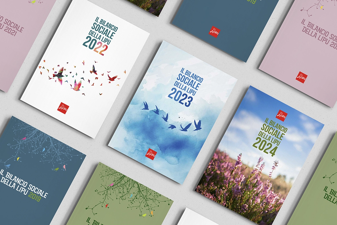 Su una superficie chiara sono disposti diversi libri colorati con copertine a tema naturalistico; sulle copertine si legge IL BILANCIO SOCIALE DELLA LIPU con vari anni.