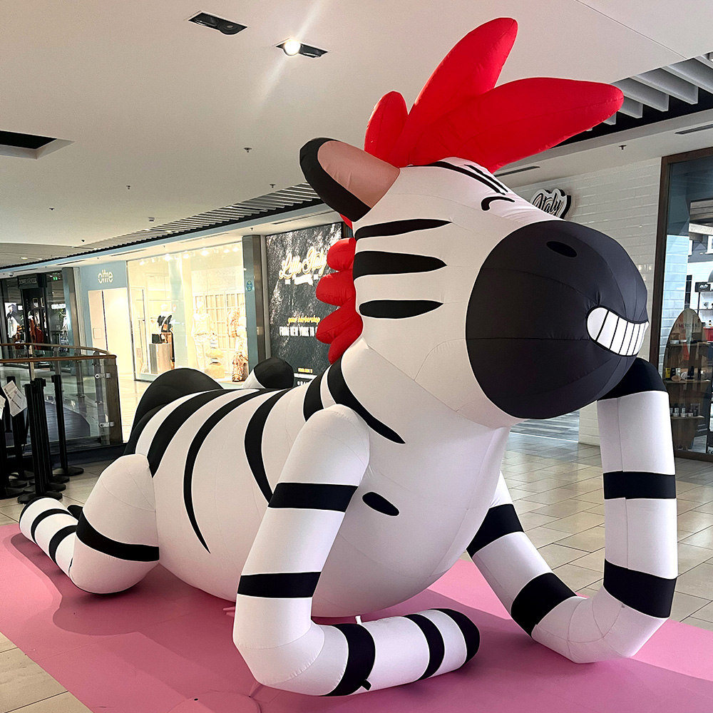 Grande zebra gonfiabile con criniera rossa e grande sorriso esposta all'interno del centro commerciale Fiumara.